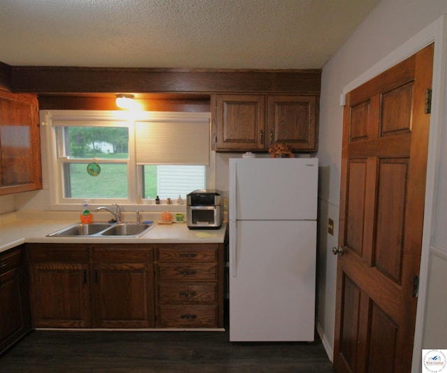 101 Lakeveiw Dr, Windsor, MO 65360 - kitchen featuring freestanding refrigerator, a sink, light countertops, dark wood finished floors, and a textured ceiling