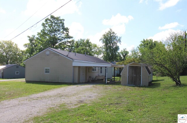 101 Lakeveiw Dr, Windsor, MO 65360 - rear view of property with dirt driveway, a yard, metal roof, and a carport