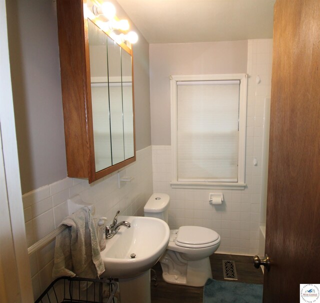 101 Lakeveiw Dr, Windsor, MO 65360 - bathroom featuring tile walls, toilet, wainscoting, and a sink