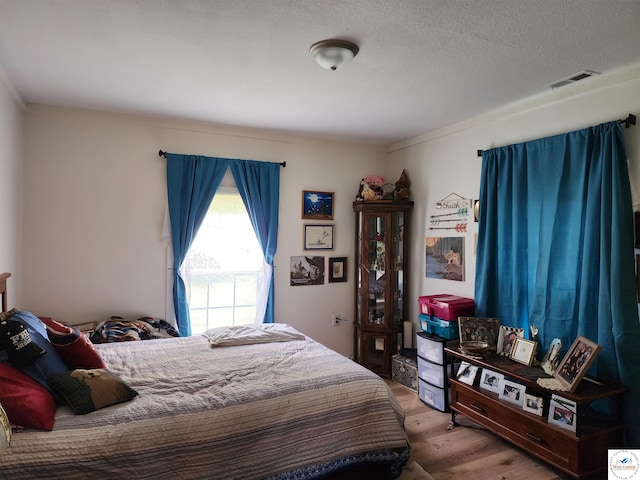 bedroom featuring wood finished floors and visible vents