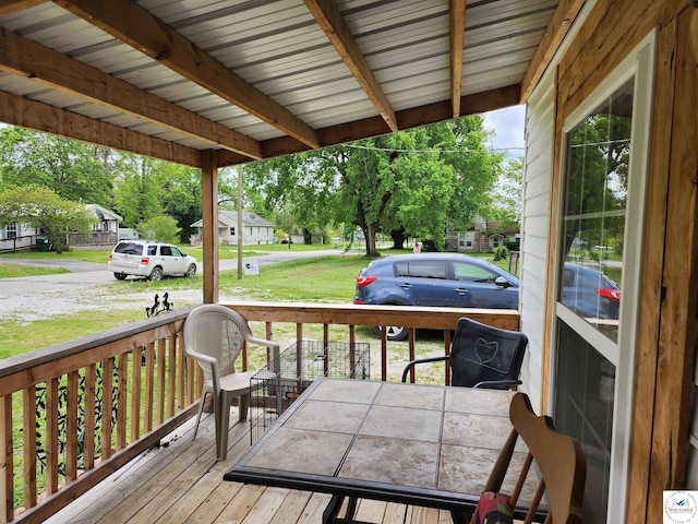 deck with a residential view, covered porch, and a yard