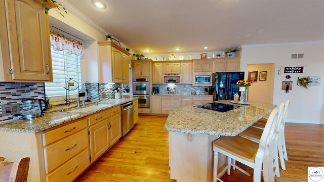 1519 Cobblestone Dr, Sedalia, MO 65301 - kitchen featuring a sink, a kitchen bar, crown molding, black appliances, and visible vents