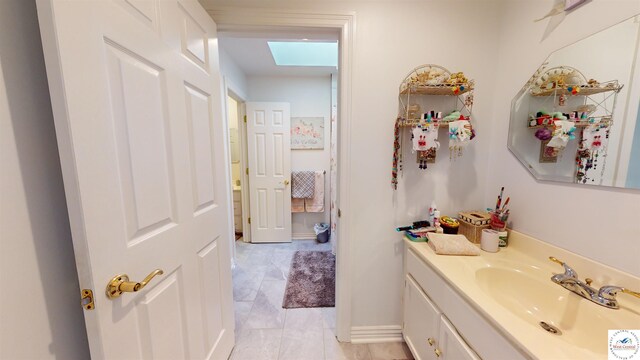 1519 Cobblestone Dr, Sedalia, MO 65301 - bathroom featuring a skylight, vanity, and baseboards