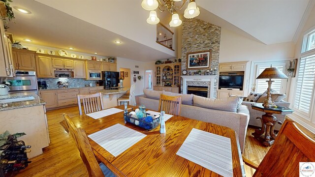 1519 Cobblestone Dr, Sedalia, MO 65301 - dining space with recessed lighting, a chandelier, a large fireplace, light wood-type flooring, and high vaulted ceiling