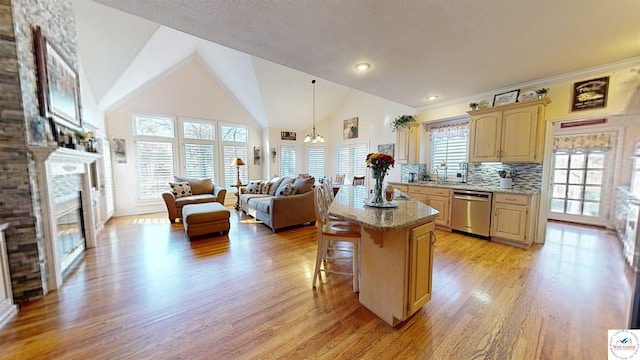 1519 Cobblestone Dr, Sedalia, MO 65301 - kitchen featuring light wood-style flooring, light brown cabinetry, dishwasher, a glass covered fireplace, and a kitchen breakfast bar