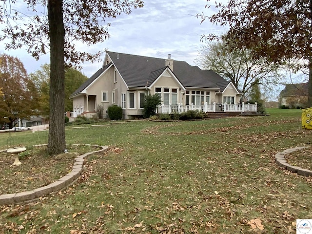 1519 Cobblestone Dr, Sedalia, MO 65301 - view of front of home with stucco siding, a chimney, a front yard, and a wooden deck