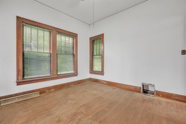 245 Randolph St, Tipton, MO 65081 - empty room with wood finished floors, plenty of natural light, visible vents, and baseboards
