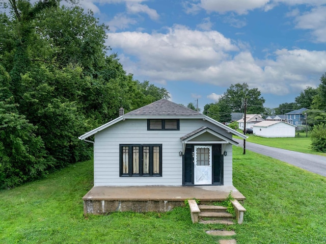245 Randolph St, Tipton, MO 65081 - bungalow featuring a shingled roof, a porch, and a front lawn