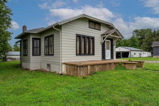 245 Randolph St, Tipton, MO 65081 - exterior space with a chimney, crawl space, and a lawn