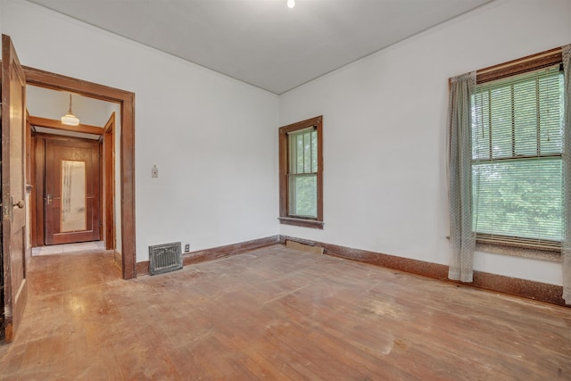 245 Randolph St, Tipton, MO 65081 - unfurnished room featuring visible vents, wood finished floors, and baseboards