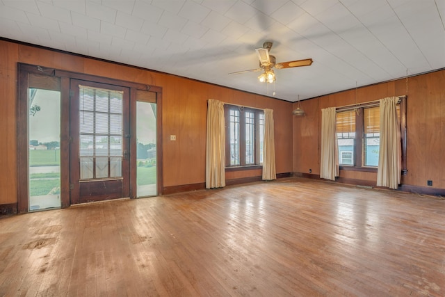 245 Randolph St, Tipton, MO 65081 - unfurnished living room with wooden walls, ceiling fan, and hardwood / wood-style floors