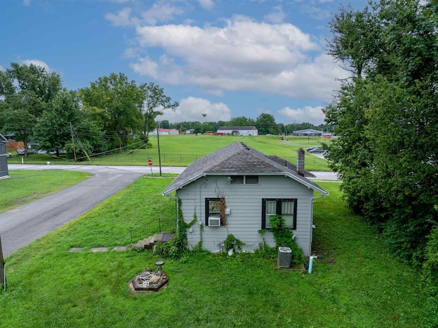 245 Randolph St, Tipton, MO 65081 - view of side of home with a lawn, cooling unit, a chimney, and central AC