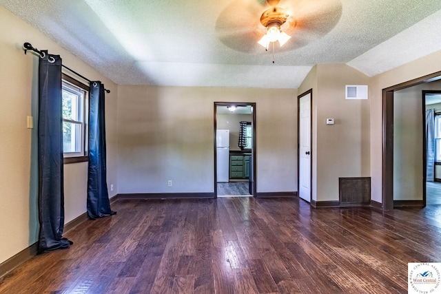 806 E Green St, Clinton, MO 64735 - empty room with dark wood-type flooring, a textured ceiling, ceiling fan, baseboards, and vaulted ceiling