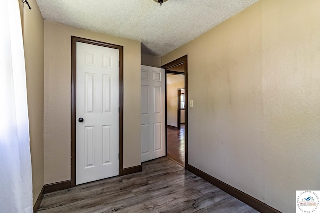 806 E Green St, Clinton, MO 64735 - unfurnished bedroom featuring a textured ceiling, wood finished floors, and baseboards