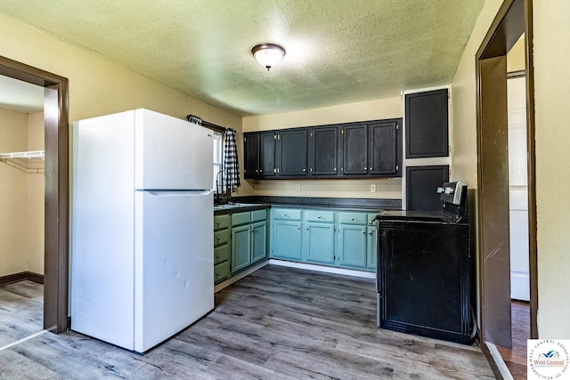 806 E Green St, Clinton, MO 64735 - kitchen with freestanding refrigerator, range, dark countertops, a textured ceiling, and dark wood-style floors