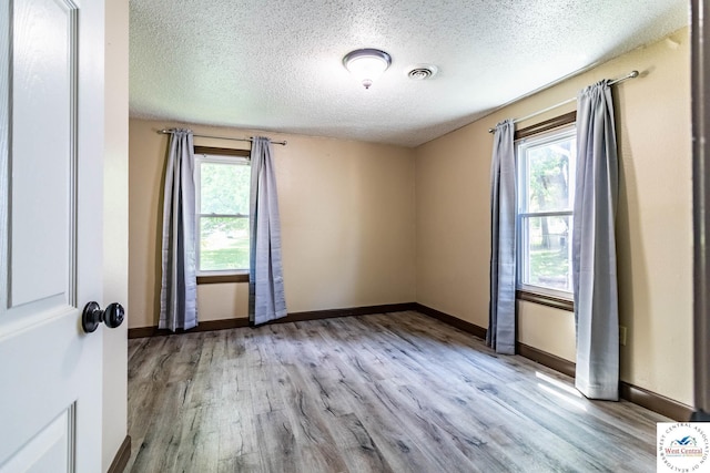 806 E Green St, Clinton, MO 64735 - spare room featuring healthy amount of natural light, wood finished floors, a textured ceiling, and baseboards