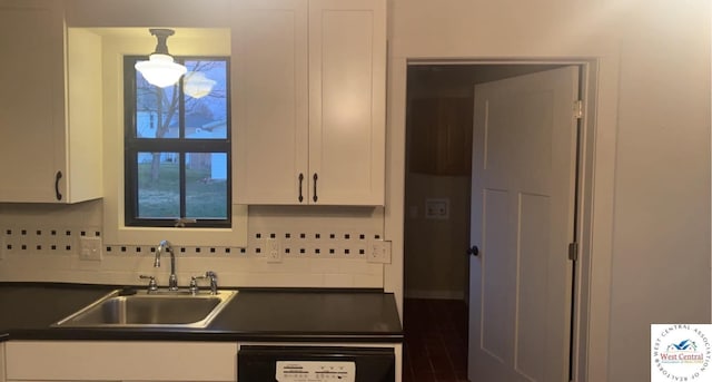202 N Maple St, Stover, MO 65078 - kitchen with dark countertops, a sink, dishwashing machine, white cabinets, and tasteful backsplash