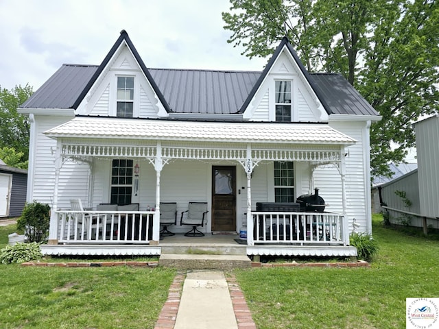 202 N Maple St, Stover, MO 65078 - view of front of house featuring covered porch, a front lawn, and metal roof