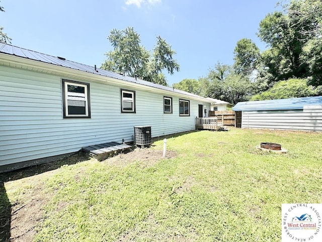 2704 Rosebud Cir, Sedalia, MO 65301 - back of house with a fire pit, a yard, a deck, and a metal roof