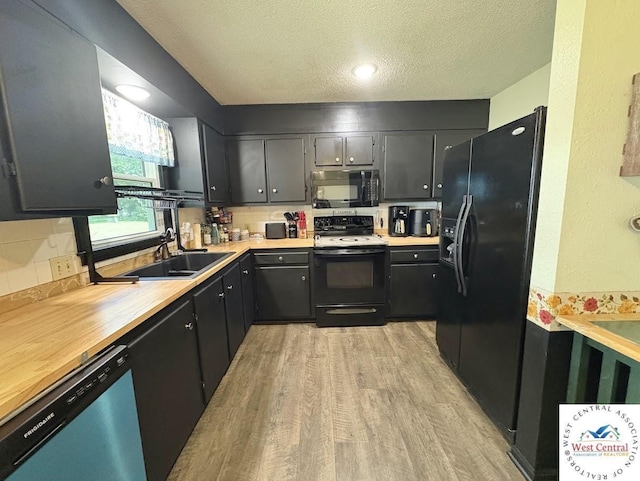 2704 Rosebud Cir, Sedalia, MO 65301 - kitchen featuring black appliances, a textured ceiling, light wood-style floors, and decorative backsplash