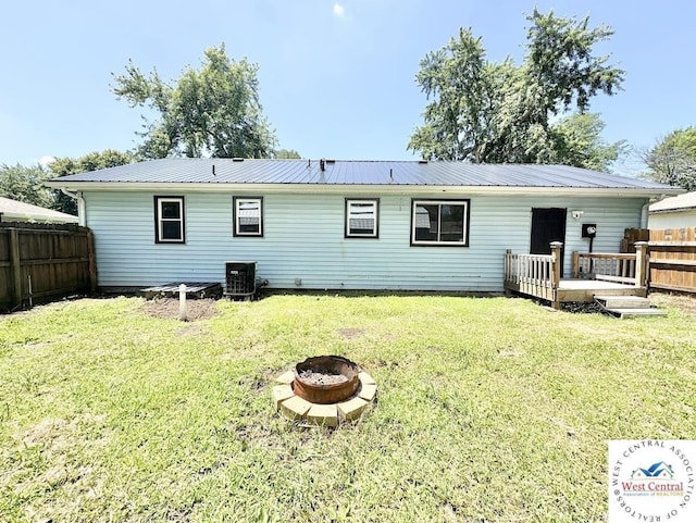 2704 Rosebud Cir, Sedalia, MO 65301 - rear view of house featuring a fire pit, a metal roof, and a wooden deck