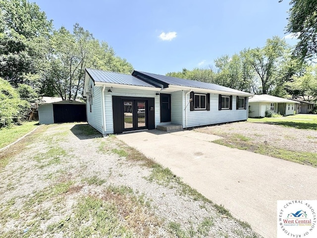 2704 Rosebud Cir, Sedalia, MO 65301 - view of front of house featuring a metal roof, driveway, and a front yard