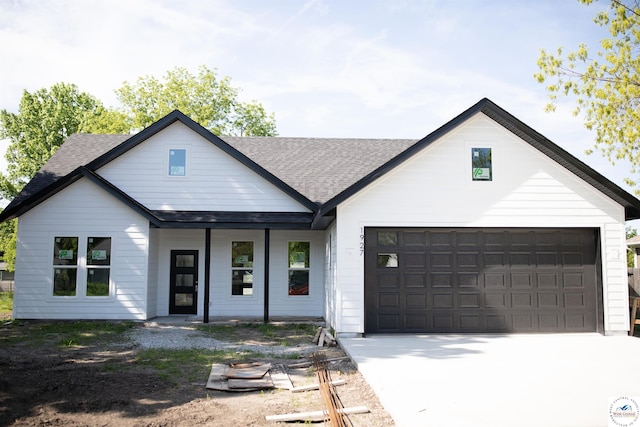 1927 E 6th St, Sedalia, MO 65301 - modern farmhouse style home with a shingled roof, covered porch, and concrete driveway