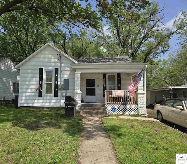 bungalow with covered porch and a front lawn