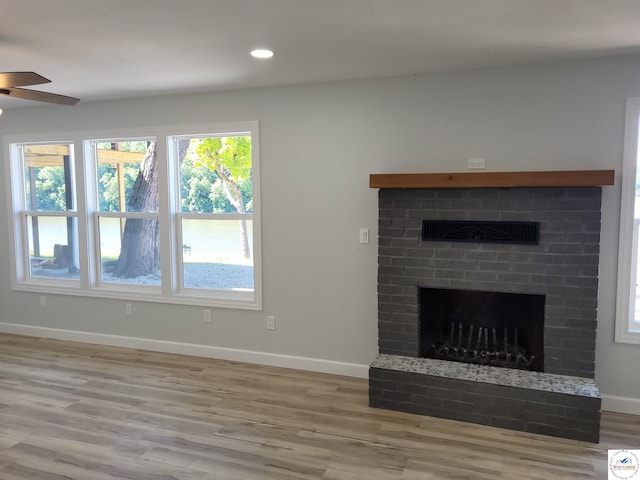 unfurnished living room featuring recessed lighting, wood finished floors, a fireplace, baseboards, and a ceiling fan