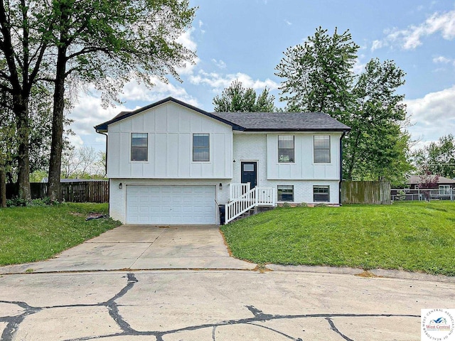 1290 E 40th Ter, Sedalia, MO 65301 - raised ranch with fence, an attached garage, board and batten siding, a front yard, and concrete driveway