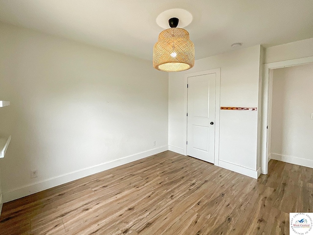unfurnished dining area featuring baseboards and wood finished floors