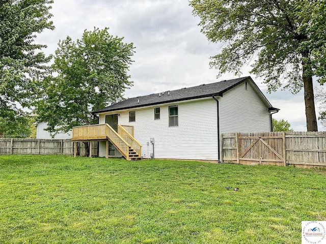 rear view of house with a fenced backyard, stairs, a lawn, and a deck