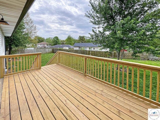 wooden terrace featuring a lawn and a fenced backyard