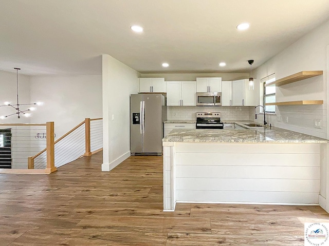 kitchen featuring stainless steel appliances, a sink, decorative backsplash, and wood finished floors