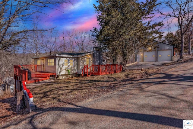 25939 Old Oar House Rd, Warsaw, MO 65355 - mid-century home featuring a wooden deck, a garage, and an outdoor structure