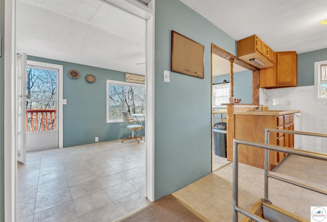 25939 Old Oar House Rd, Warsaw, MO 65355 - kitchen featuring healthy amount of natural light, light tile patterned floors, a textured ceiling, and brown cabinets