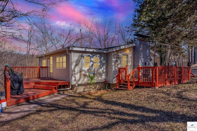 25939 Old Oar House Rd, Warsaw, MO 65355 - back of house at dusk with a deck, a lawn, and a chimney