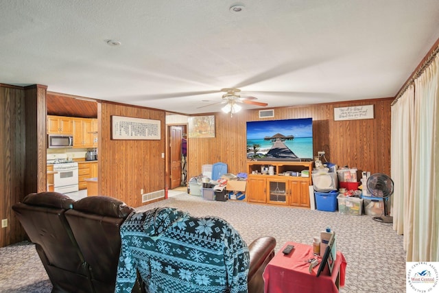 828 SE 601st Rd, Leeton, MO 64761 - carpeted living room featuring ceiling fan and wood walls