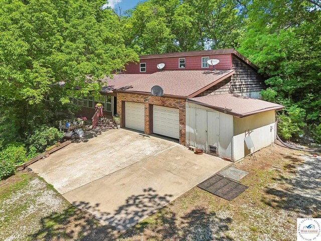 828 SE 601st Rd, Leeton, MO 64761 - view of front facade with a shingled roof, driveway, and an attached garage