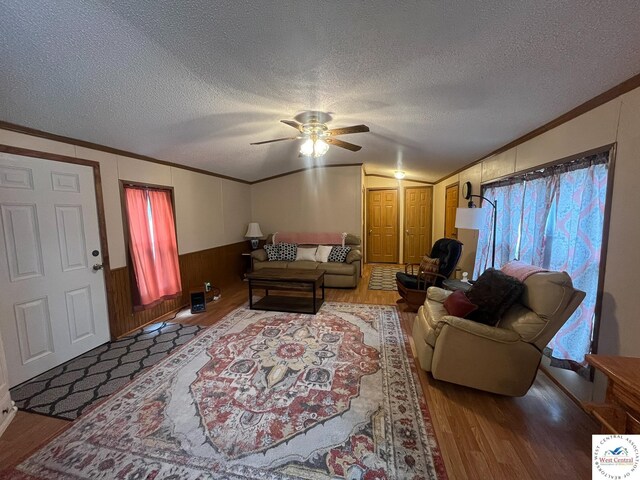 31674 Aspen Rd, Stover, MO 65078 - living room featuring wood finished floors, ornamental molding, ceiling fan, a textured ceiling, and wood walls