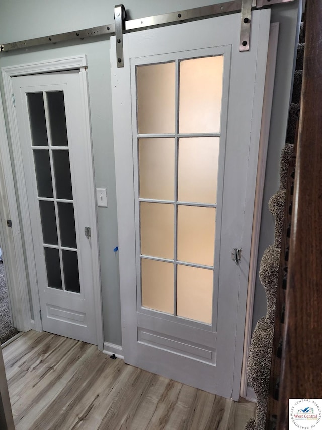 10075 Otter Rd, Clinton, MO 64735 - doorway featuring light wood-type flooring, baseboards, and a barn door