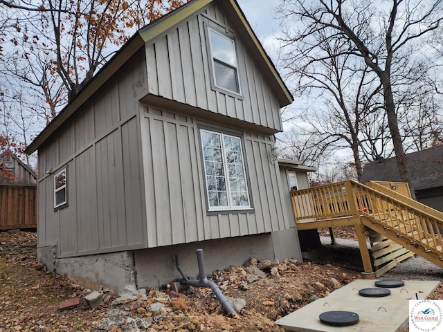 10075 Otter Rd, Clinton, MO 64735 - view of side of home with stairs, a deck, fence, and board and batten siding