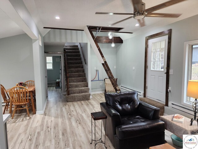 10075 Otter Rd, Clinton, MO 64735 - living room featuring a baseboard heating unit, light wood finished floors, a ceiling fan, stairway, and recessed lighting