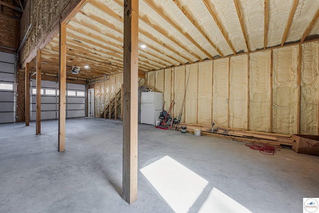 garage featuring freestanding refrigerator and a garage door opener