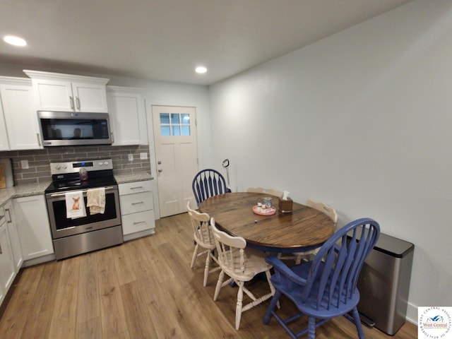 29790 Bobcat Dr, Warsaw, MO 65355 - kitchen featuring appliances with stainless steel finishes, decorative backsplash, recessed lighting, light wood-type flooring, and white cabinets
