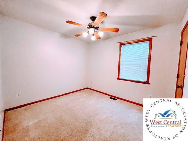 spare room with baseboards, ceiling fan, carpet floors, and visible vents