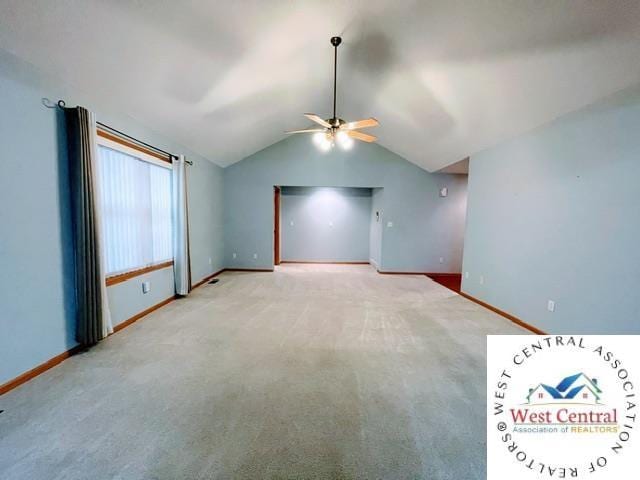 spare room with baseboards, ceiling fan, vaulted ceiling, and carpet floors