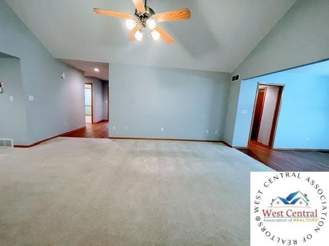 interior space featuring baseboards, ceiling fan, visible vents, and vaulted ceiling