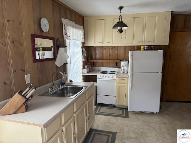 19094 Kennedy Rd, Warsaw, MO 65355 - kitchen with white appliances, a sink, wood walls, cream cabinets, and pendant lighting