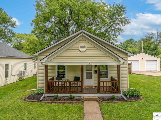 1803 S Quincy Ave, Sedalia, MO 65301 - shotgun-style home featuring covered porch, a front lawn, a detached garage, an outbuilding, and ac unit